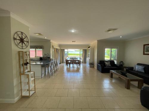 a large living room with a couch and a table at Spacious resort style property with pool in Mudgee - Rest Easy Mudgee Villa in Mudgee