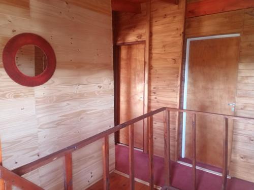 a staircase in a wooden cabin with a mirror at Cabaña Sion in Puerto Madryn
