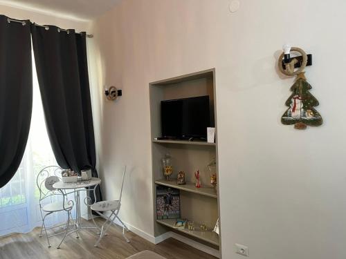 ein Wohnzimmer mit einem TV und einem Regal in der Unterkunft Casa Myluna Centro Storico in Neapel