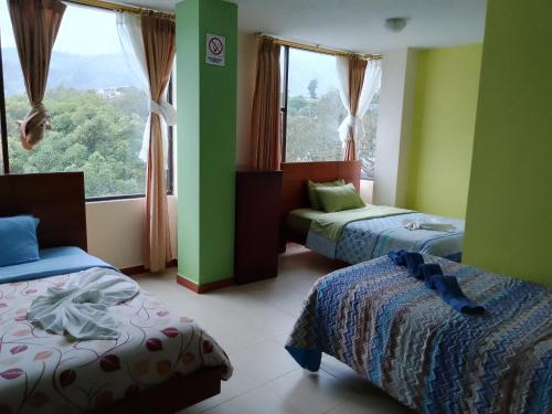 Cette chambre comprend deux lits et une grande fenêtre. dans l'établissement Hostal Casa del Valle, 