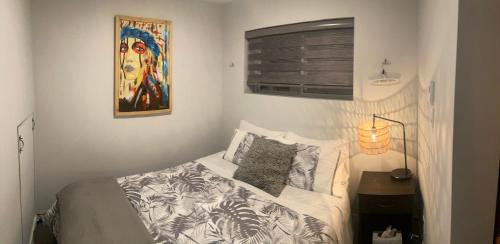 1 dormitorio con 1 cama y una pintura en la pared en Le Monk ,chalet, motoneige, quad ,nature, randonné pédestre, en Montmagny