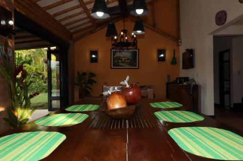 a dining room table with green plates and an apple in a bowl at Villas Panaca Portal 1 in Quimbaya