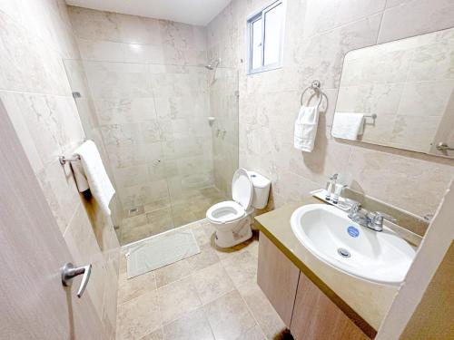 a bathroom with a sink and a toilet and a mirror at Hostal El Cielo in Cartagena de Indias