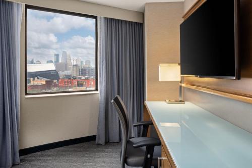 a hotel room with a desk and a large window at Courtyard by Marriott Minneapolis Downtown in Minneapolis