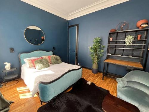 - une chambre bleue avec un lit et une chaise dans l'établissement Appartement au coeur de Caen, à Caen
