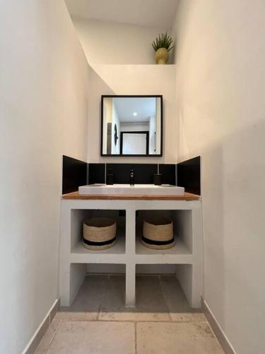 une salle de bain avec un lavabo et un miroir dans l'établissement Appartement au coeur de Caen, à Caen