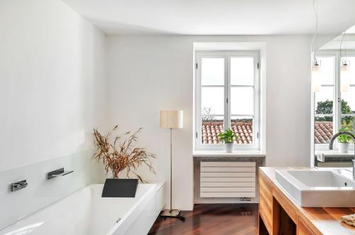 Komen的住宿－Hiša Ana，白色浴室设有两个盥洗盆和两个窗户。