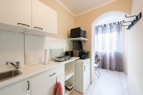 a kitchen with white cabinets and a window at Sweet in Budapest