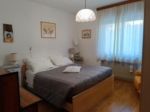 een slaapkamer met een bed en een kroonluchter bij Famiglia Brochetti in Balbido-rango