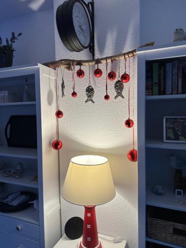 a room with a lamp and a clock and christmas decorations at Feriendomizil Dornum Haus Margarete mit Wallbox in Dornum