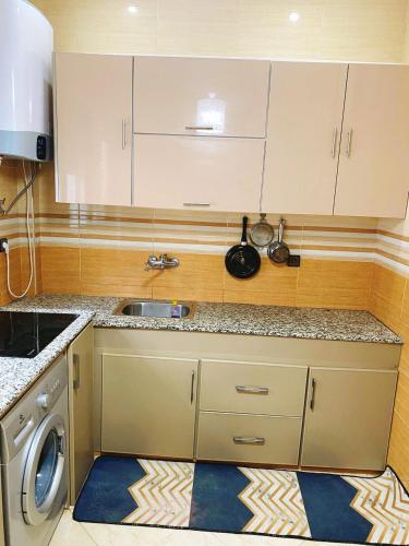 a kitchen with a sink and a washing machine at Appartement calme in Fès