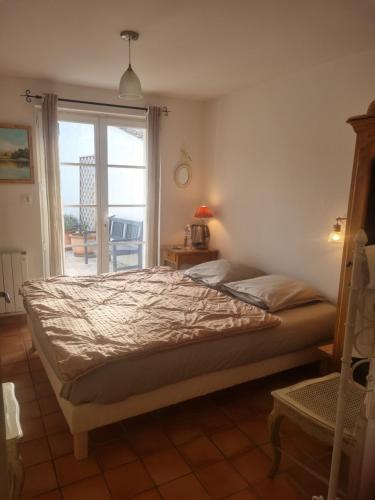 a bedroom with a bed and a window with a patio at Chambre d'hôte Montlivault / Chambord in Montlivault