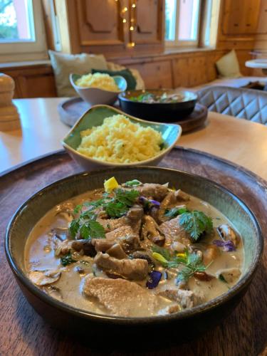 a table with a bowl of food on a table at Hotel & Restaurant Grüner Baum Merzhausen in Freiburg im Breisgau