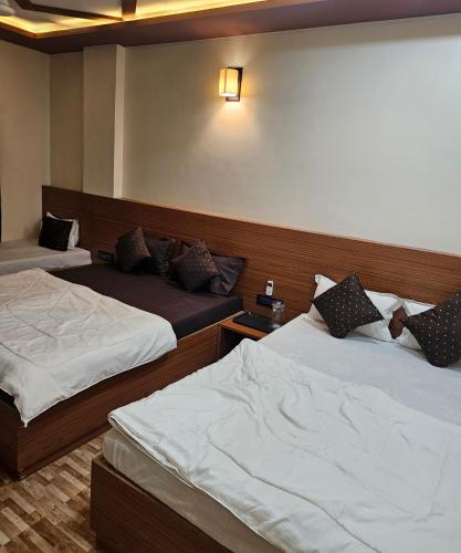 a hotel room with two beds in a room at Hotel Sai Dakshina Inn & The Fern Restaurant in Shirdi