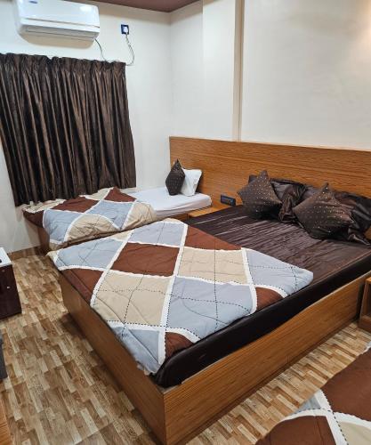 a bedroom with two beds in a room at Hotel Sai Dakshina Inn & The Fern Restaurant in Shirdi