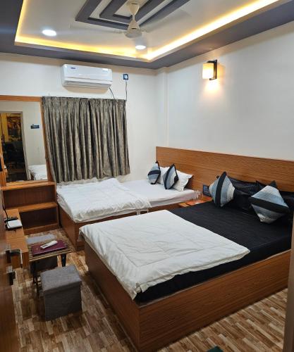 a bedroom with two beds and a window at Hotel Sai Dakshina Inn & The Fern Restaurant in Shirdi