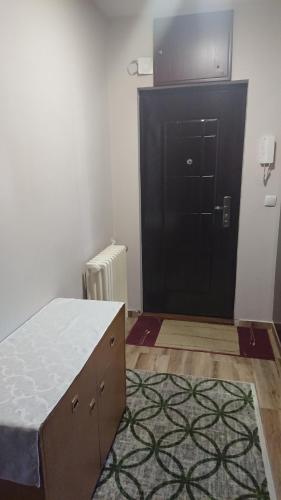 a bedroom with a bed and a black door at Apartman Jellena in Pale