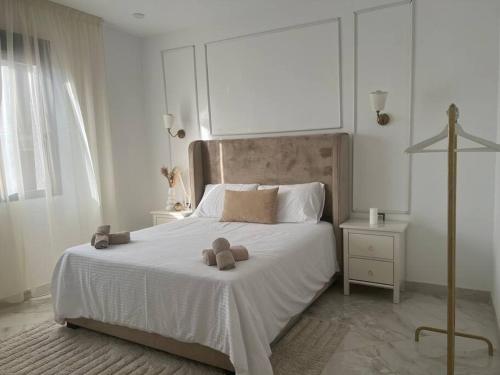 a bedroom with a white bed with two teddy bears on it at Luxueux T3 à Oran. in Oran