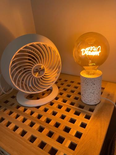 a fan on a table next to a lamp at Daisy House - Whittington - 10 minutes to central Geelong in Whittington