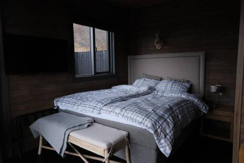 a bedroom with a large bed and a chair at Luxury 2-Bedroom Lodge in the South of Iceland in Reykholt