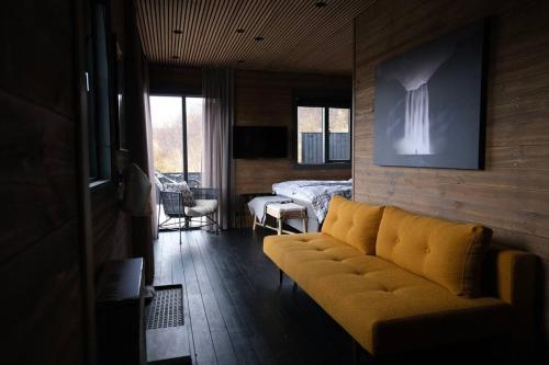 a living room with a yellow couch and a bed at Luxury 2-Bedroom Lodge in the South of Iceland in Reykholt