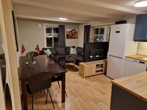 uma cozinha e sala de estar com uma mesa e um sofá em Apartment next to the bridge em Tromsø