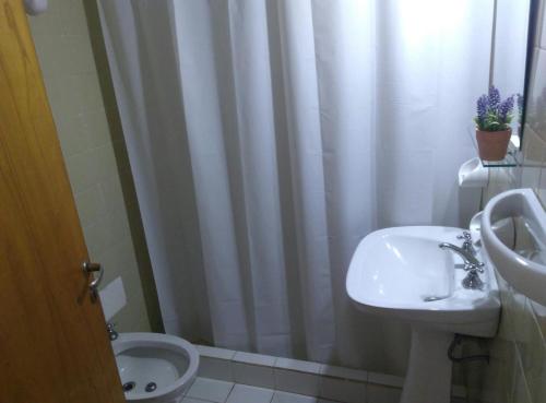 uma casa de banho com um lavatório, um WC e uma cortina de chuveiro. em Monoambiente céntrico con balcón - Posadas, Misiones em Posadas