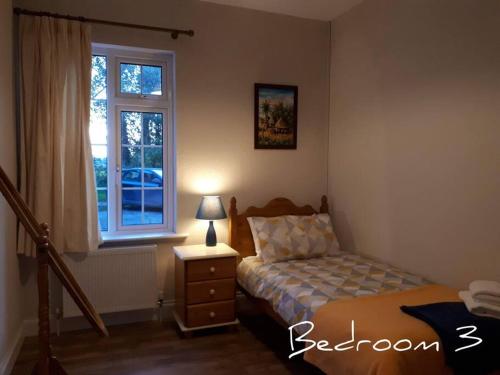 - une chambre avec un lit et une fenêtre dans l'établissement Family Home, 20 mins from Youghal Beach, à Killeagh