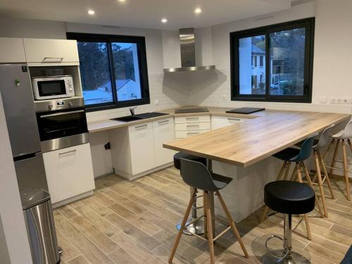 une cuisine avec un comptoir en bois et une table en bois dans l'établissement Maison 8 pers 1 minute parc des expositions, à Bohars