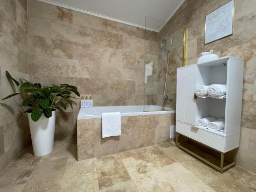 e bagno con vasca, servizi igienici e pianta. di Florilor Residence II a Piteşti