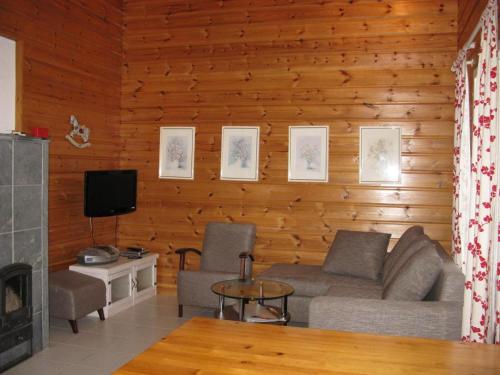 a living room with a couch and a tv at Koli Country Club in Hattusaari