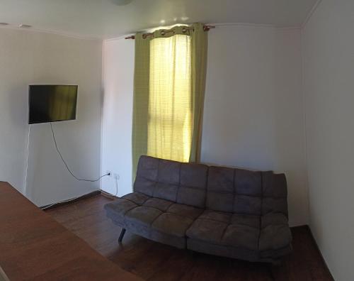 un salon avec un canapé et une télévision dans l'établissement Condominio Doña Jacinta, à Valdivia