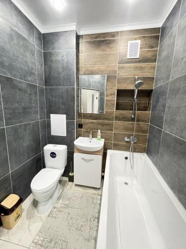 a bathroom with a toilet and a tub and a sink at # 22 Яркая и уютная квартира MODERN in Atyrau