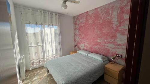- une chambre avec un lit et un mur rouge dans l'établissement Babu Home Bcn, à Santa Coloma de Cervelló