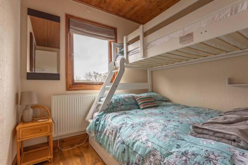 a bedroom with a bunk bed with a ladder at Wharfe Lodge in Skipton