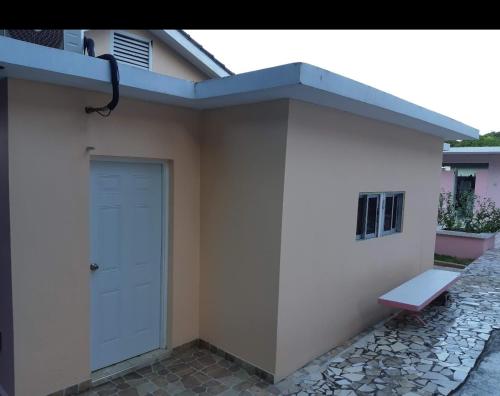 a building with a door and a bench next to it at Cliff Apartment in Kingston