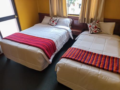 dos camas sentadas una al lado de la otra en una habitación en Huaraz Center Hostal, en Huaraz
