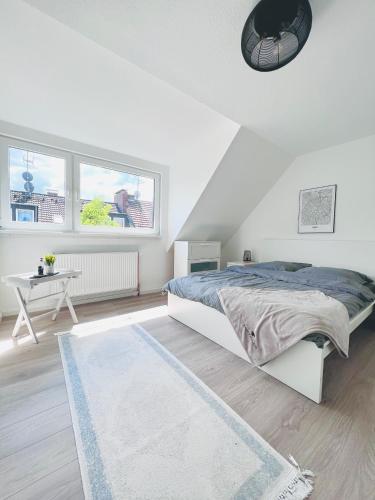 een witte slaapkamer met een bed en een tafel bij Voll ausgestattet und gemütlich in Wuppertal
