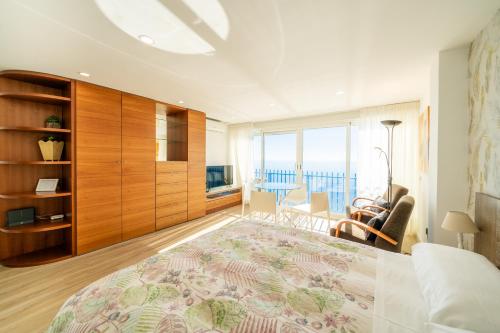 1 dormitorio con 1 cama grande y sala de estar en Primera línea playa levante Benidorm, en Benidorm