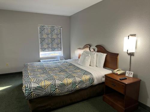 Una habitación de hotel con una cama y una computadora portátil encima. en Star City Inn & Suites, en Star City