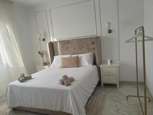 a white bed with a teddy bear on it at Luxueux T3 à Oran. in Oran