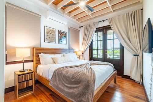 Un dormitorio con una cama grande y una ventana en Livengood Properties BZ+The PoolClub@Mahogany Bay! en San Pedro