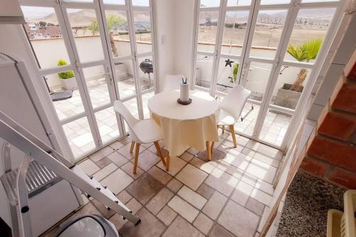a white table and chairs in a room with windows at Hermoso Penthouse con jacuzzi en terraza in Lima