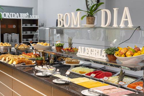 a buffet line with many different types of food at Hotel Negrini in Balneário Camboriú