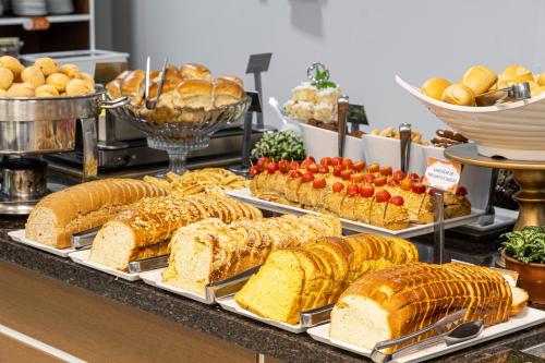 un buffet con muchos tipos diferentes de pan y fruta en Hotel Negrini, en Balneário Camboriú