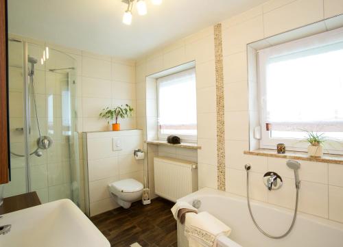 La salle de bains est pourvue d'une baignoire, de toilettes et d'un lavabo. dans l'établissement Ferienhaus Endl, à Freyung
