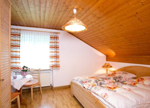 a bedroom with a bed and a table and a window at Ferienhaus Endl in Freyung