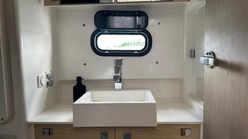a bathroom with a white sink and a window at Room in Boat - Unusual night in catamaran with dinner in Grand Case