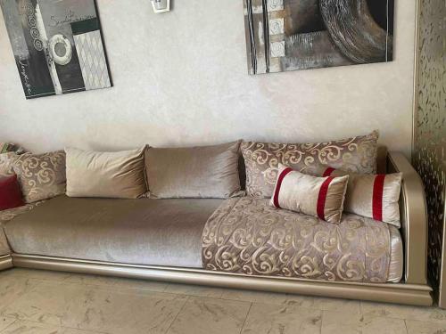 a couch with two pillows on it in a room at Appart bien équipé avec jardin privé à California in Casablanca