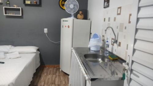 a small kitchen with a sink and a refrigerator at Hospedagem Santo Agostinho in Extrema